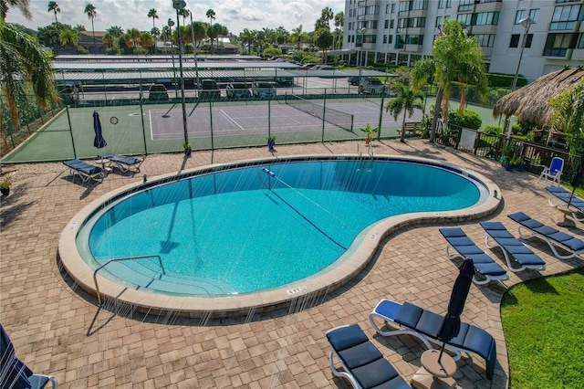 view of pool with tennis court