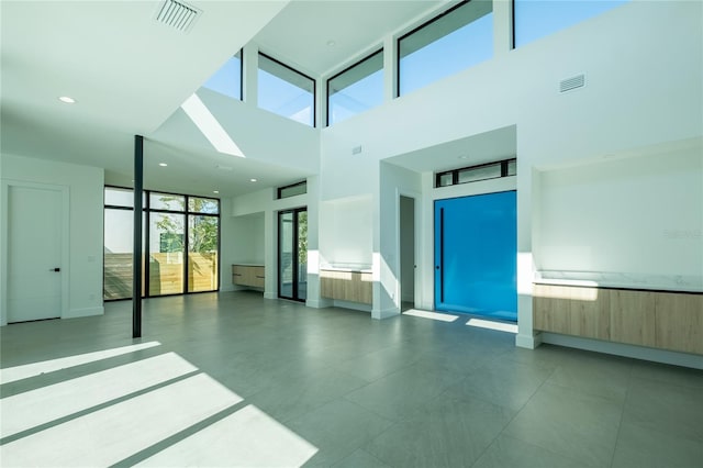 unfurnished room featuring a high ceiling and elevator