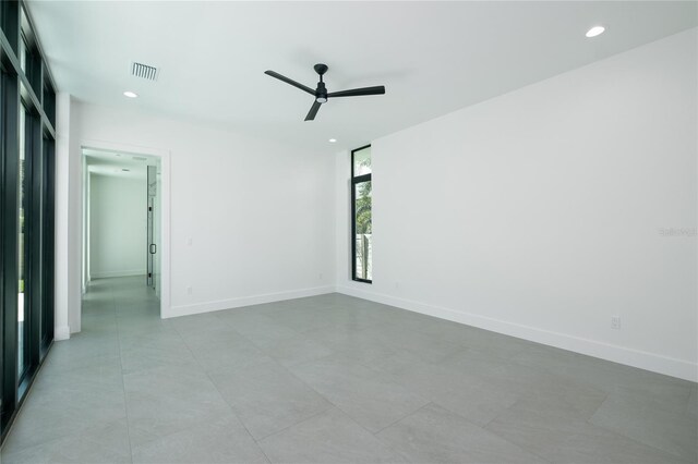 empty room with ceiling fan and light tile patterned floors