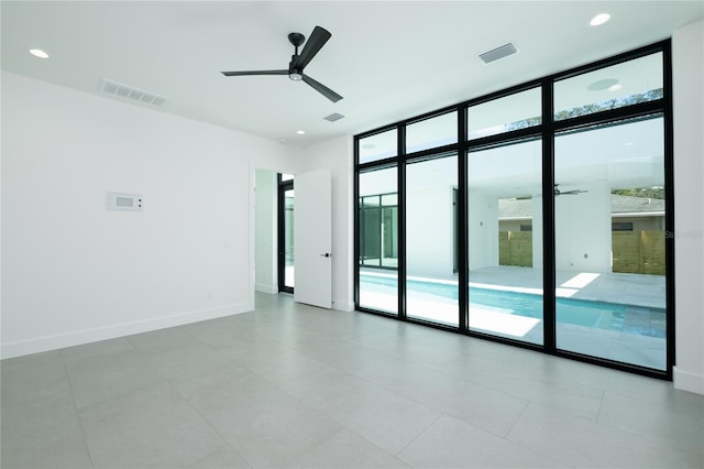 unfurnished room with ceiling fan, a wealth of natural light, and light tile patterned floors