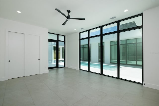 interior space with ceiling fan and floor to ceiling windows