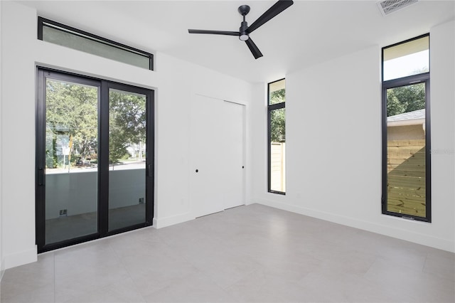 tiled empty room featuring ceiling fan