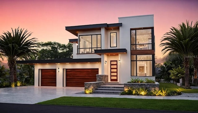 contemporary house featuring driveway, an attached garage, and stucco siding