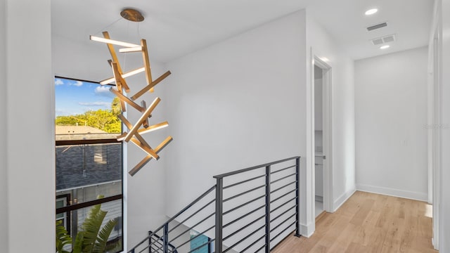 stairway with recessed lighting, visible vents, baseboards, and wood finished floors