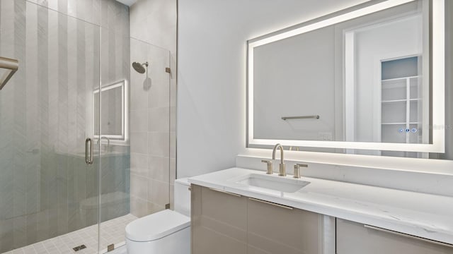 bathroom with a stall shower, vanity, and toilet
