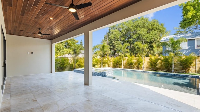 view of swimming pool with a ceiling fan, a pool with connected hot tub, a patio, and fence