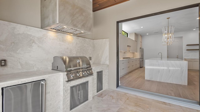 kitchen with refrigerator, tasteful backsplash, hanging light fixtures, modern cabinets, and stainless steel fridge with ice dispenser