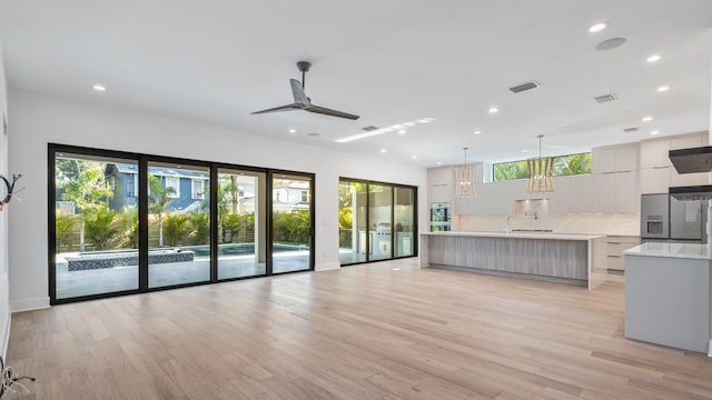 unfurnished living room with light wood-style floors, visible vents, and recessed lighting