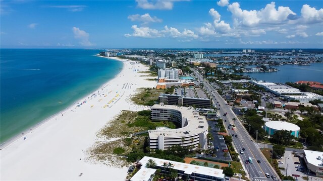 birds eye view of property featuring a water view and a beach view