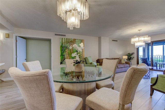 dining room with an inviting chandelier and light hardwood / wood-style flooring