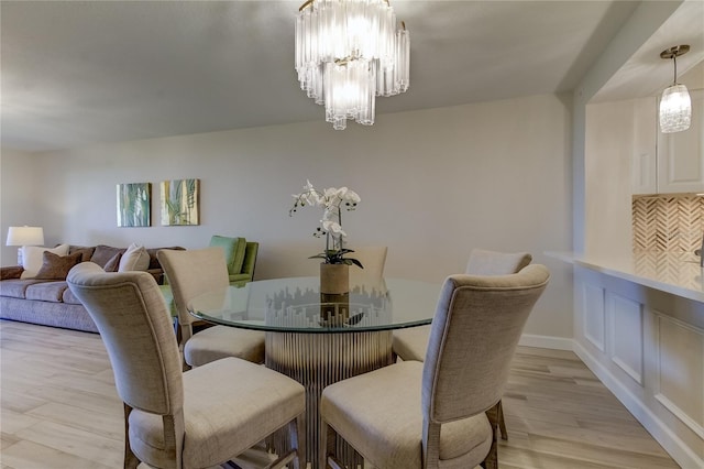 dining area with a chandelier and light hardwood / wood-style flooring