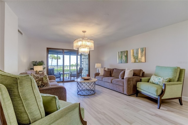 living room featuring a chandelier and light hardwood / wood-style floors