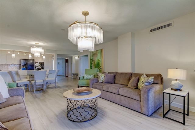 living room featuring light hardwood / wood-style flooring and a notable chandelier