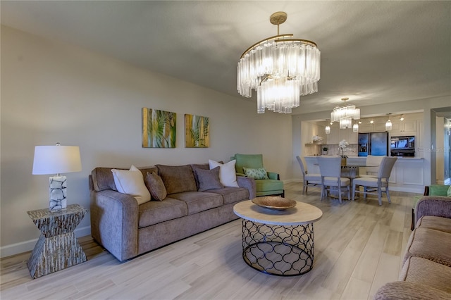 living room with an inviting chandelier and light hardwood / wood-style floors