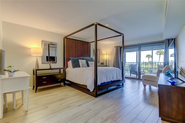 bedroom featuring light wood-type flooring and access to outside