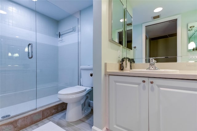 bathroom with walk in shower, vanity, and toilet