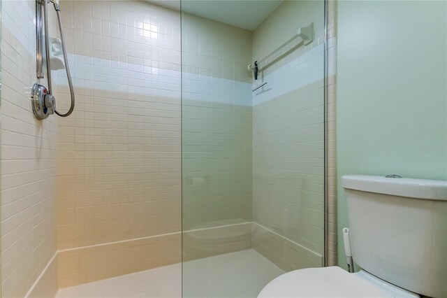 bathroom featuring toilet and tiled shower