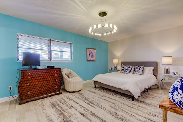 bedroom with a notable chandelier and wood-type flooring