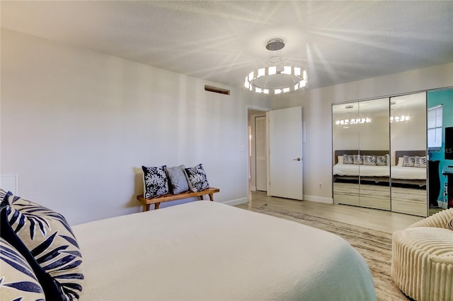 bedroom with an inviting chandelier and light wood-type flooring