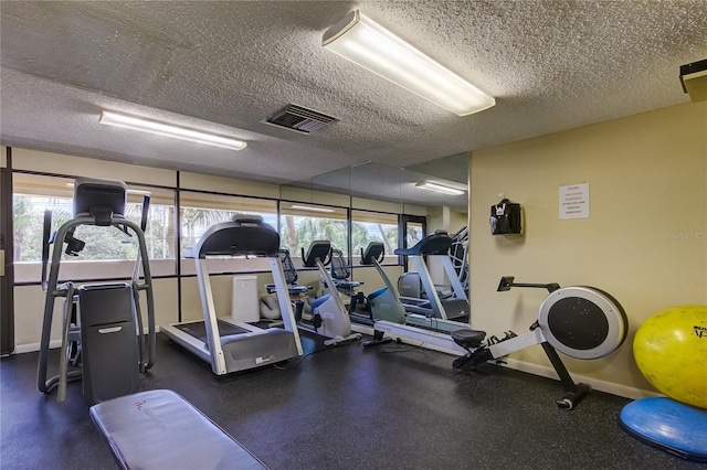 gym featuring plenty of natural light and a textured ceiling