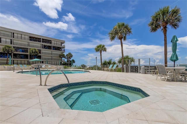 view of pool with a hot tub and a patio