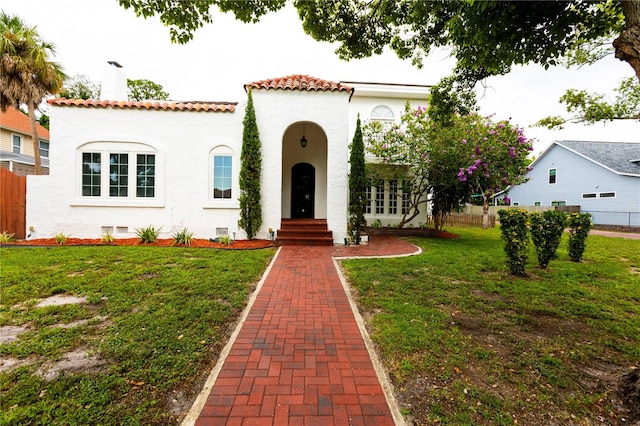 mediterranean / spanish home featuring a front lawn