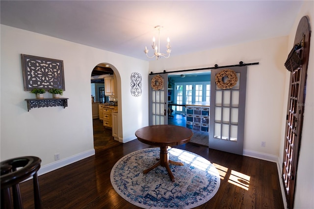 interior space featuring an inviting chandelier, dark wood-type flooring, and a barn door