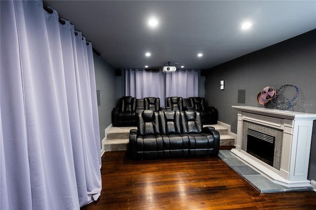 home theater with dark hardwood / wood-style flooring and a tiled fireplace