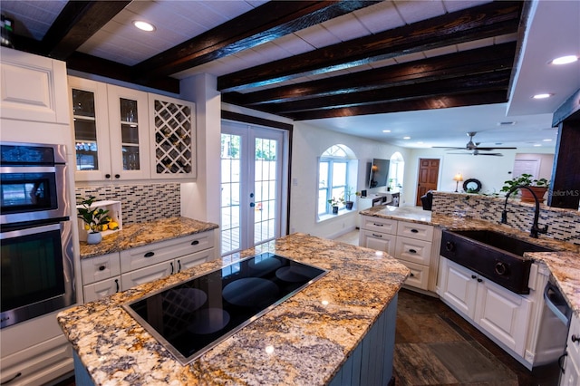 kitchen featuring a center island, appliances with stainless steel finishes, sink, and white cabinets