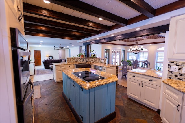 kitchen featuring sink, white cabinets, a center island, black electric stovetop, and kitchen peninsula