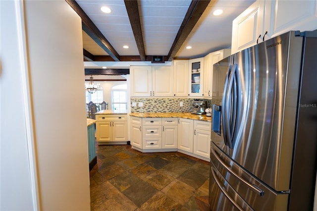 kitchen featuring stainless steel fridge, backsplash, beam ceiling, light stone countertops, and white cabinets