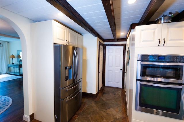 kitchen featuring stainless steel appliances, beam ceiling, and white cabinets