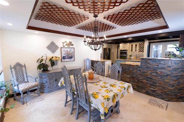 dining room with a raised ceiling and a notable chandelier