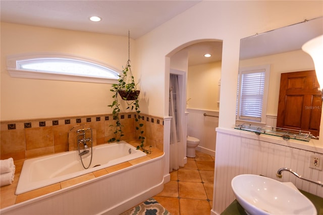 bathroom featuring tile patterned flooring, sink, a bathing tub, and toilet