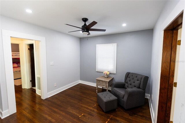 living area with dark wood-type flooring and ceiling fan