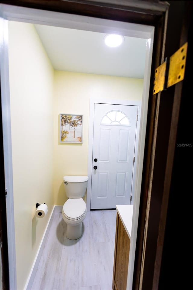 bathroom with hardwood / wood-style flooring, vanity, and toilet