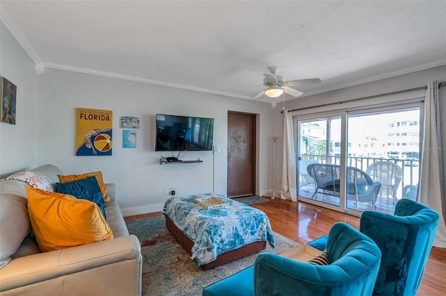 living room featuring crown molding, baseboards, and wood finished floors