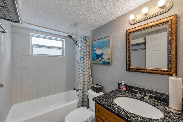 full bath featuring a textured ceiling, a textured wall, toilet, shower / tub combo, and vanity