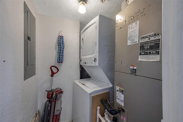 laundry room with stacked washer / dryer, laundry area, electric panel, and a textured wall