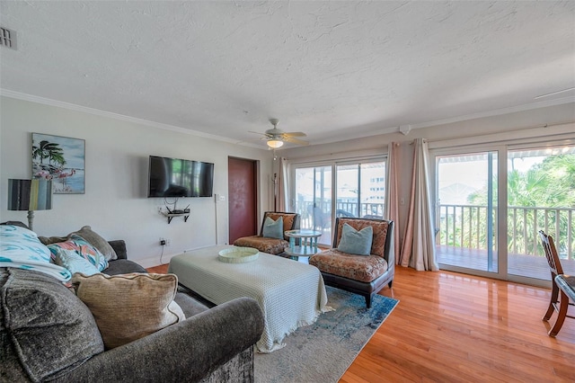 living area featuring a textured ceiling, ornamental molding, and wood finished floors