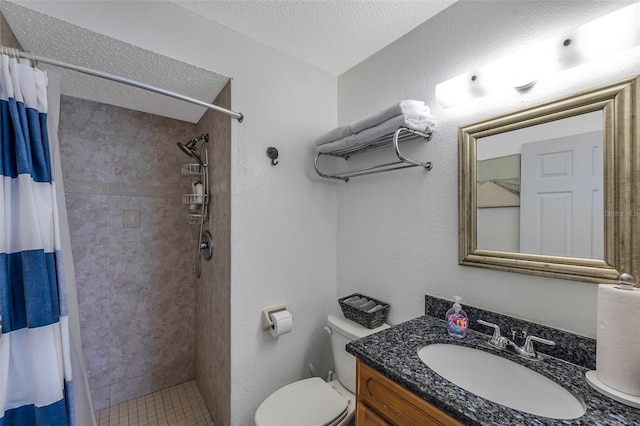 bathroom with toilet, a shower stall, a textured ceiling, and vanity