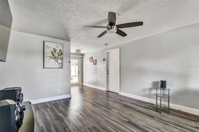 living room featuring dark wood-type flooring, a textured ceiling, and ceiling fan