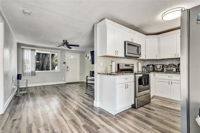 kitchen with ceiling fan, light hardwood / wood-style flooring, stainless steel appliances, and white cabinets