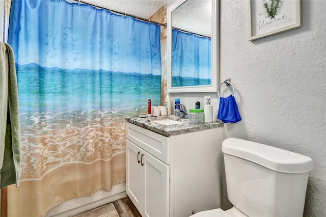 full bathroom with a textured wall, toilet, wood finished floors, a textured ceiling, and vanity