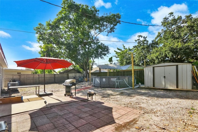 view of patio with a shed and a grill