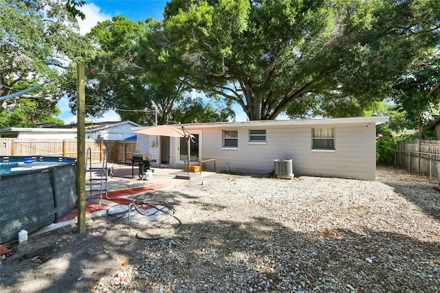 rear view of property featuring cooling unit, a fenced backyard, and a patio