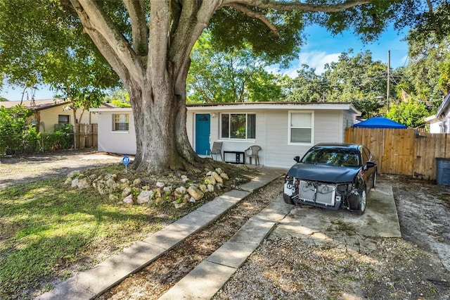 ranch-style home featuring fence