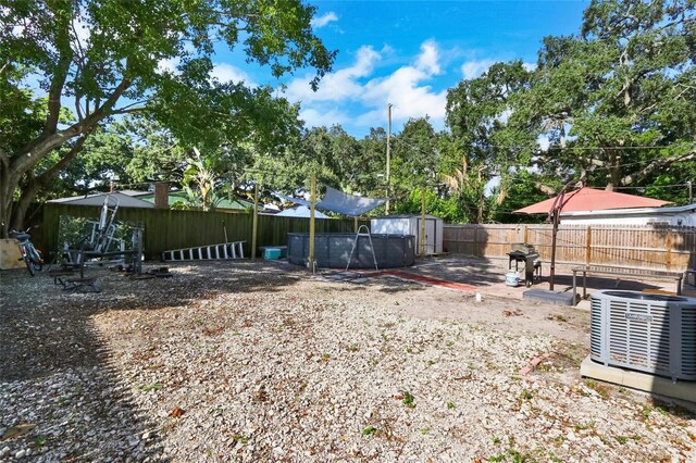 view of yard featuring a storage shed and cooling unit