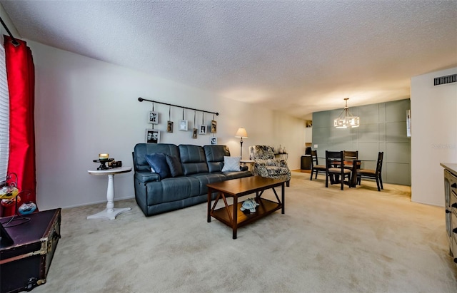 carpeted living room with a chandelier and a textured ceiling