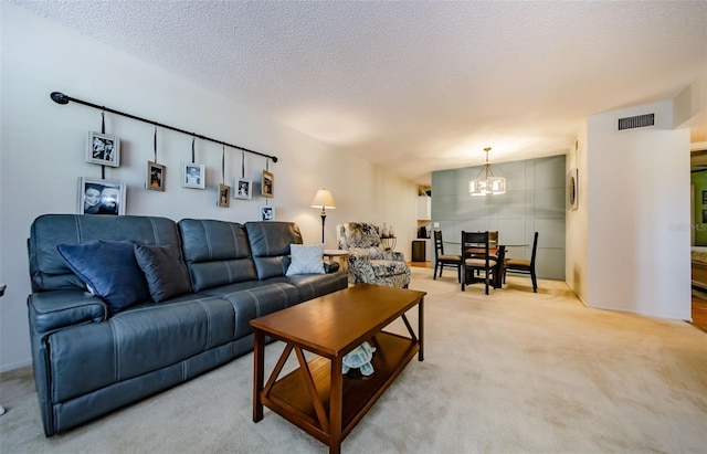 carpeted living room featuring a notable chandelier and a textured ceiling